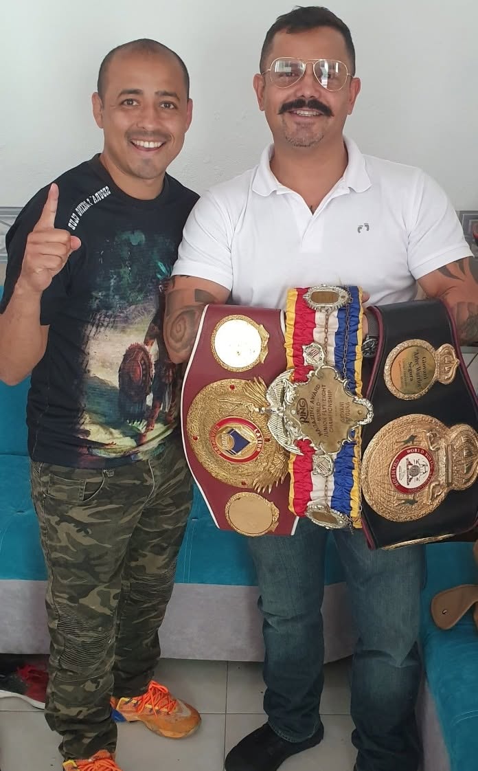 Deportista campeón con cinturones de título junto al equipo de Alphabiotista Sanador Deportivo Élite
